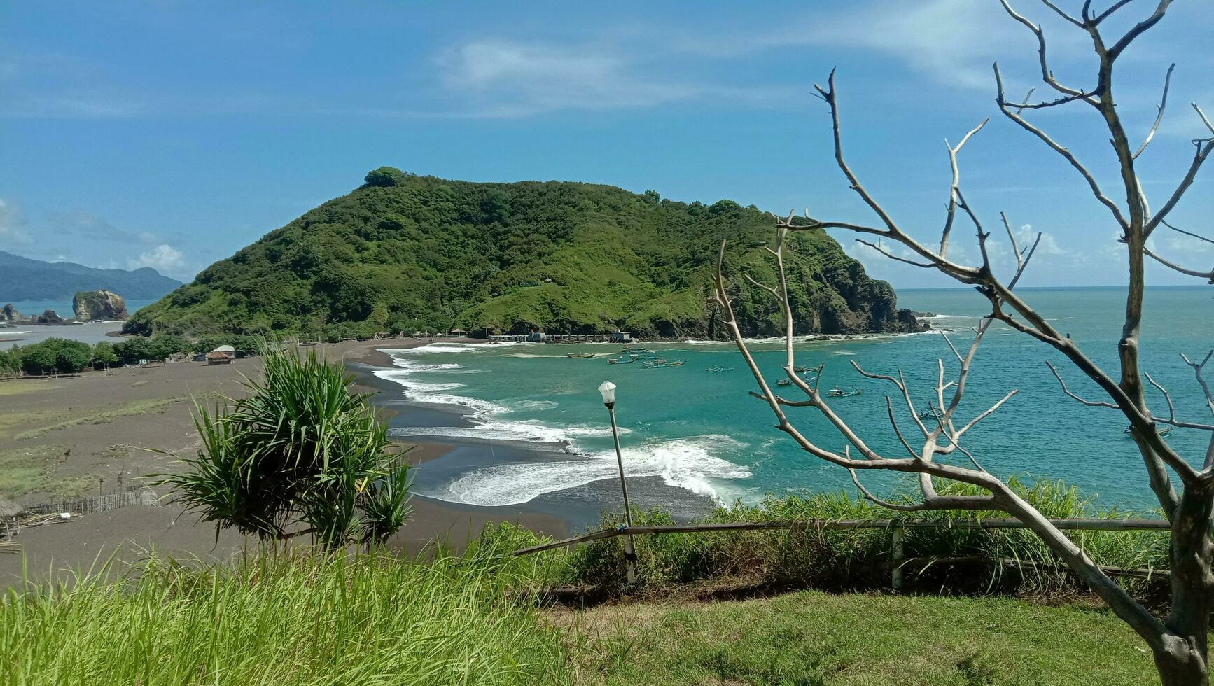 keer bekeken van de kust in Indonesië vergezeld door heuvels van bomen foto