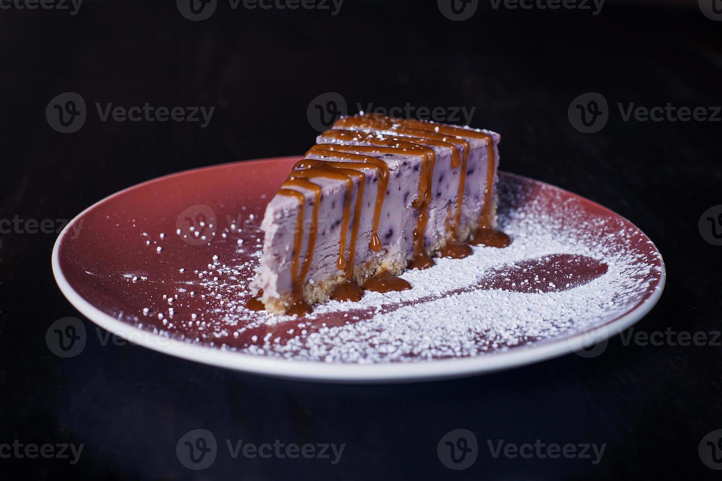 zoete dessertcake op een bord, mooie portie, donkere achtergrond foto