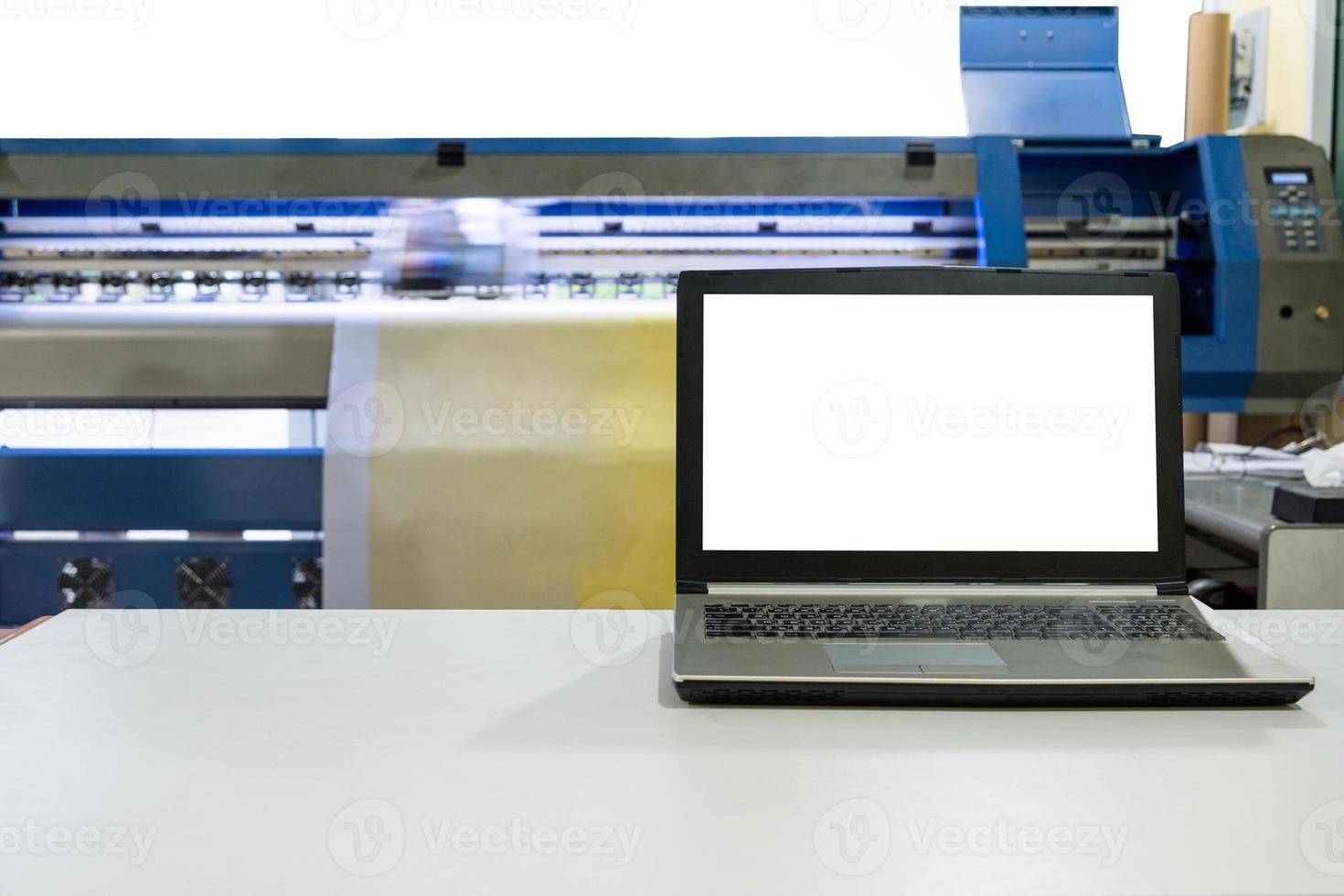 grote inkjetprinter bezig met vinylbanner met notebookscherm foto