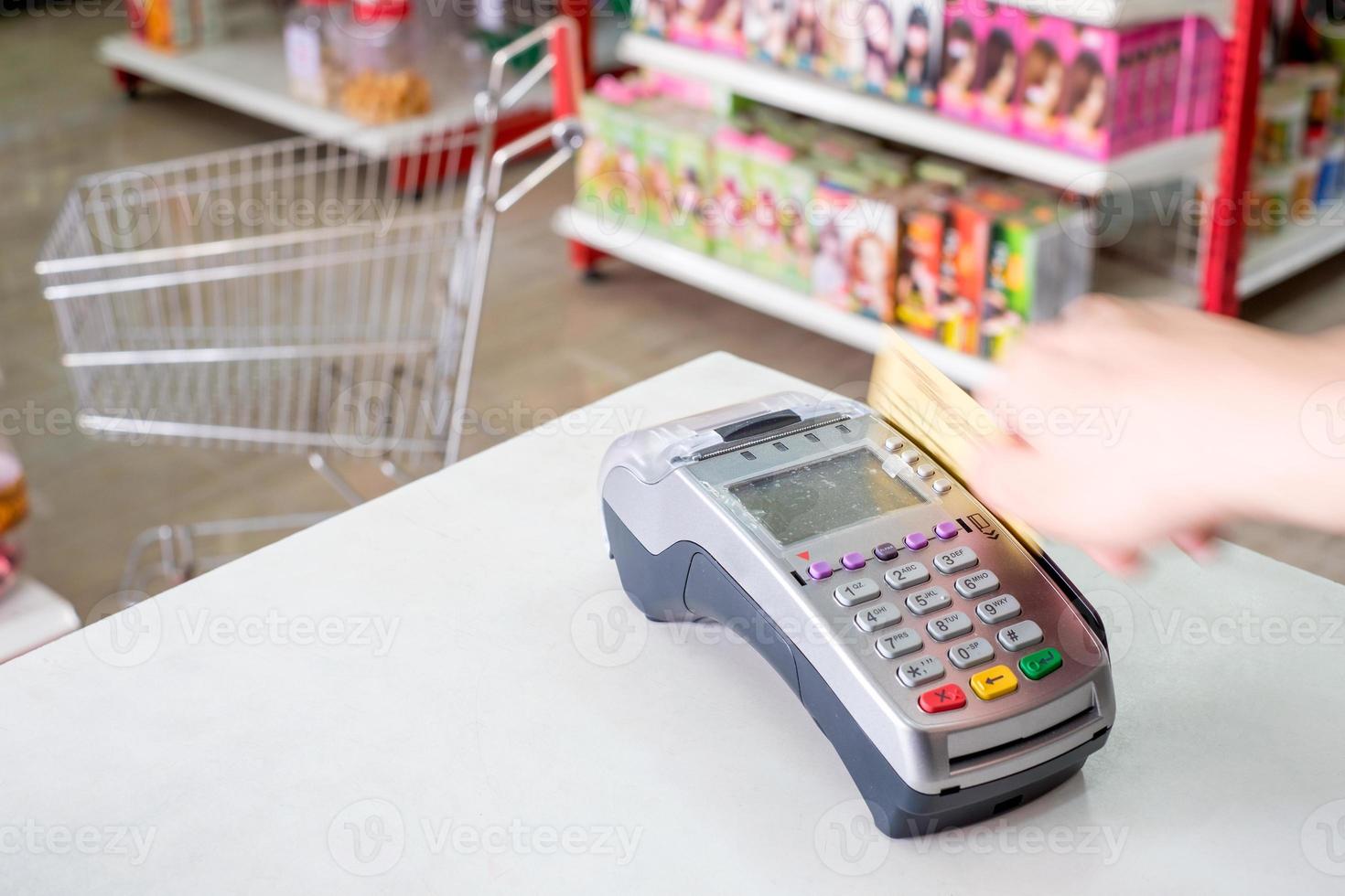 hand vegen creditcard op betaalterminal in winkel foto