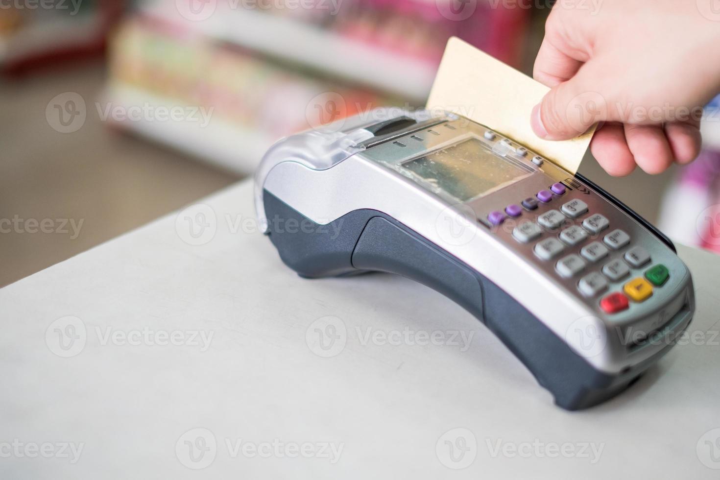 hand vegen creditcard op betaalterminal in winkel foto