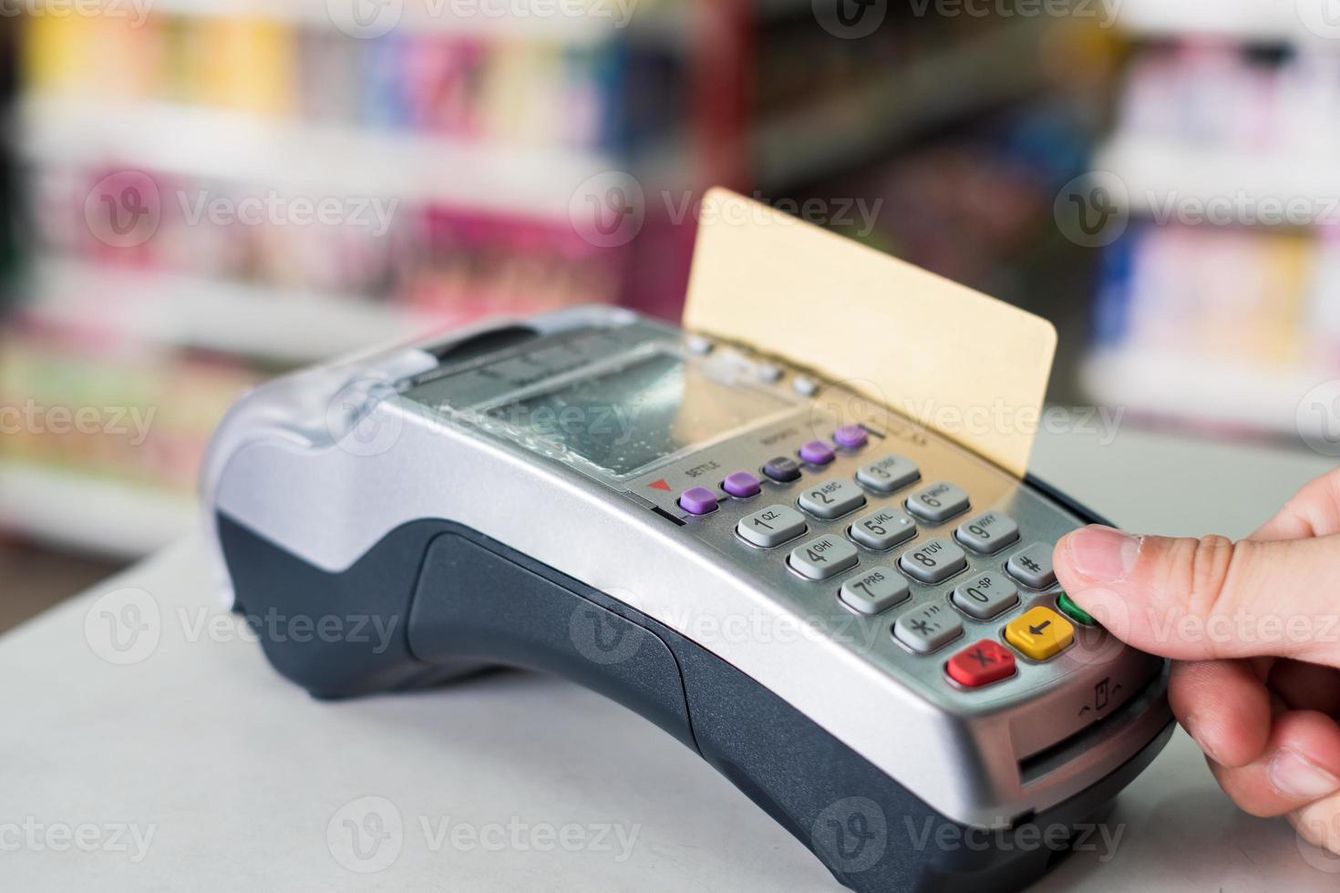 handpers met vegende creditcard op betaalterminal in winkel foto