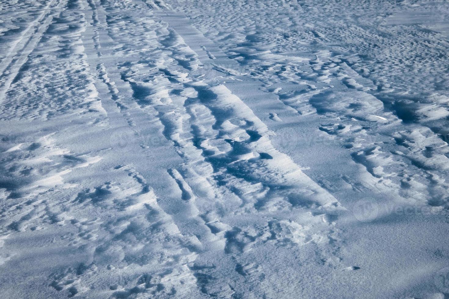 groef op besneeuwde heuvel met stromend windpatroon foto