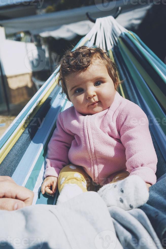 kleine baby die plezier heeft in een hangmat op een zonnige dag foto