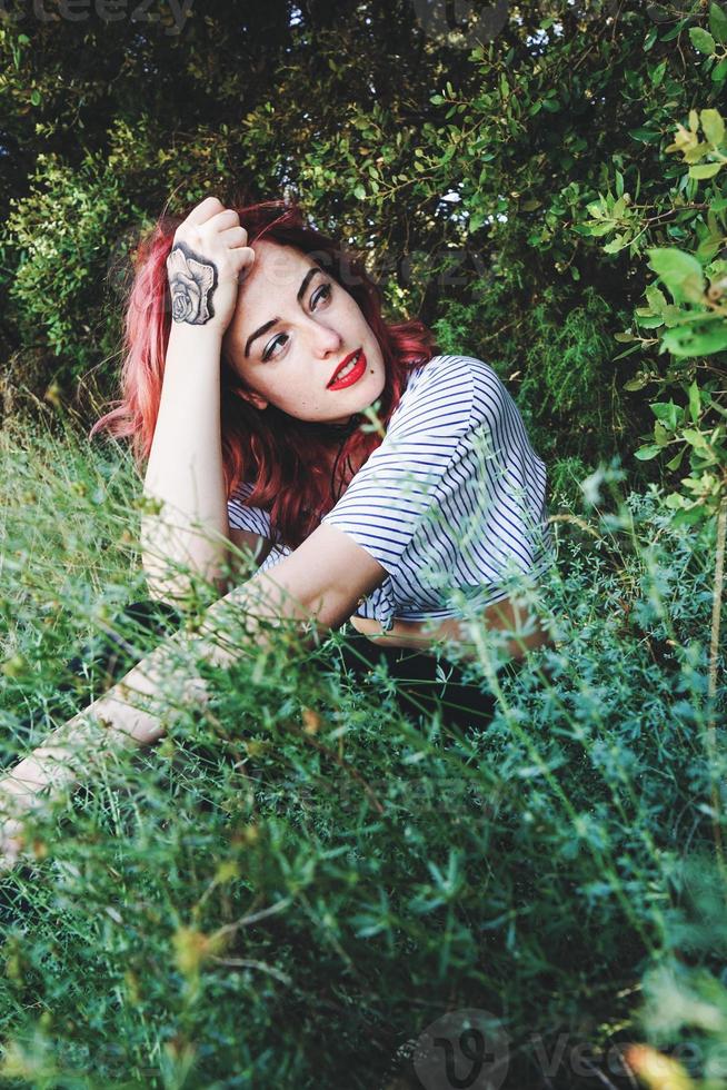 jonge en mooie roodharige vrouw poseren midden in de natuur foto