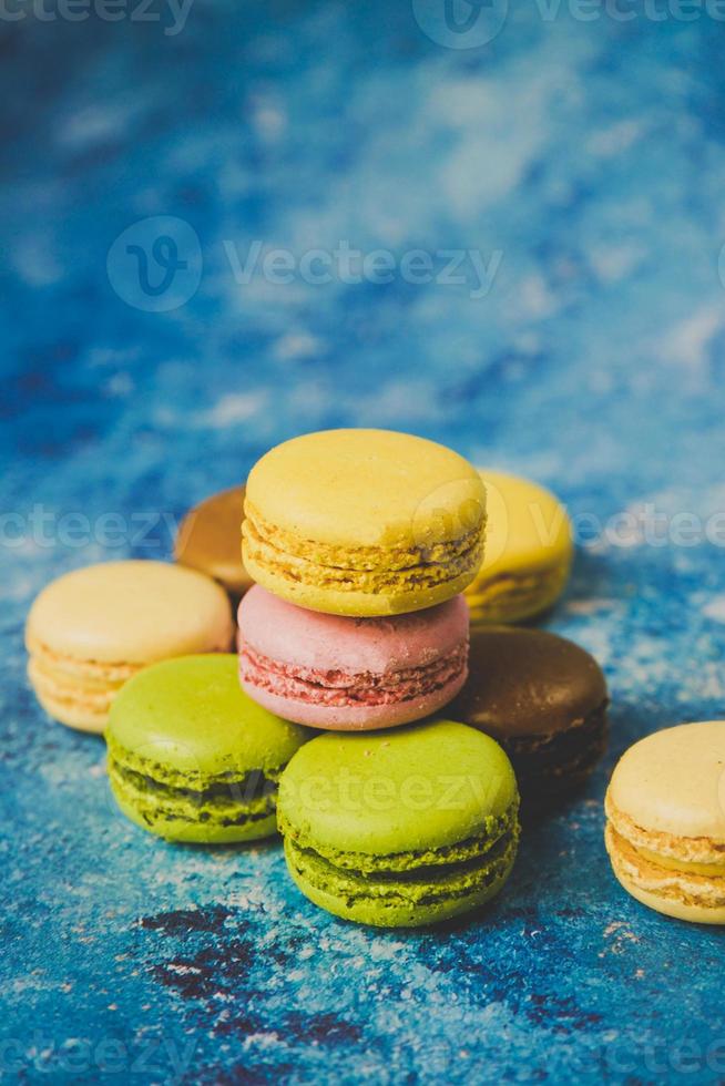 verscheidenheid aan kleurrijke macarons op een blauwe achtergrond foto