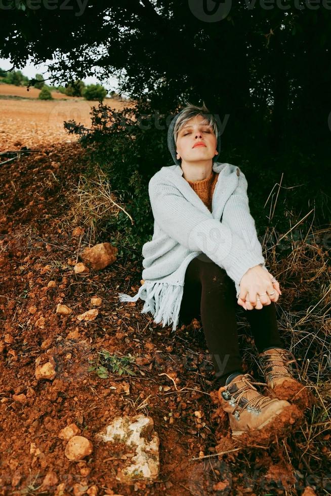 vrouw van middelbare leeftijd alleen in de natuur in een koude herfstdag foto