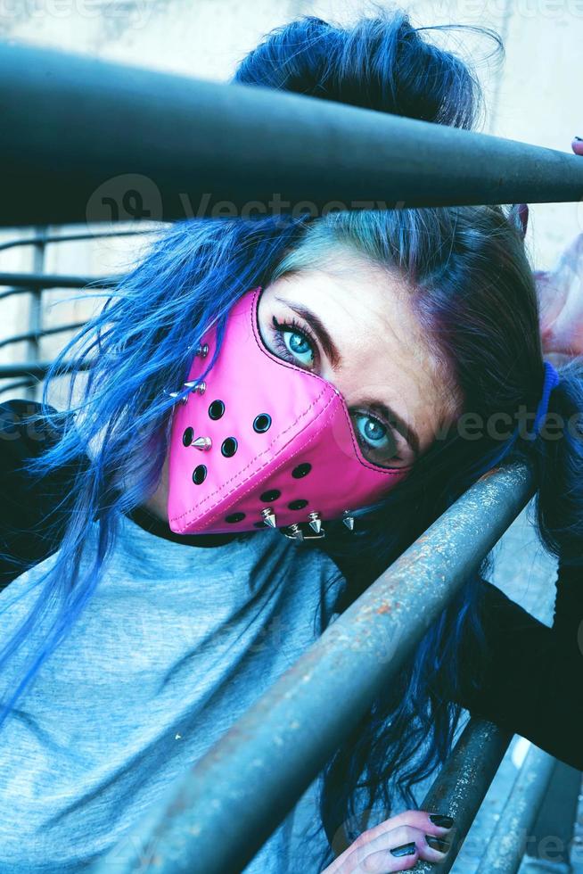 jonge punkvrouw met een roze masker foto