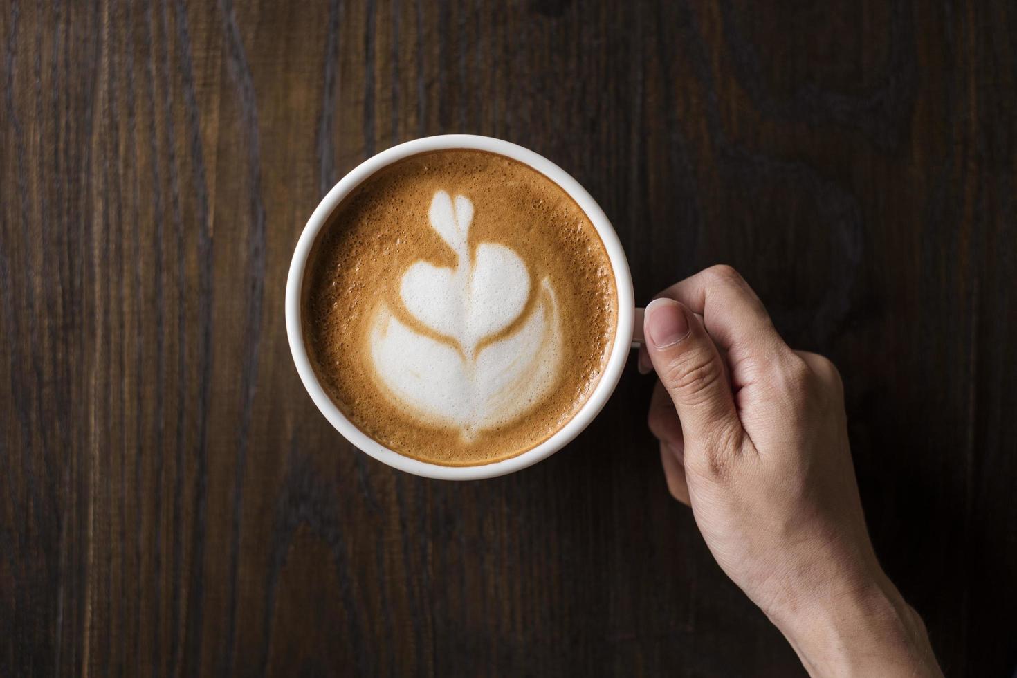 hete latte art op houten tafel foto