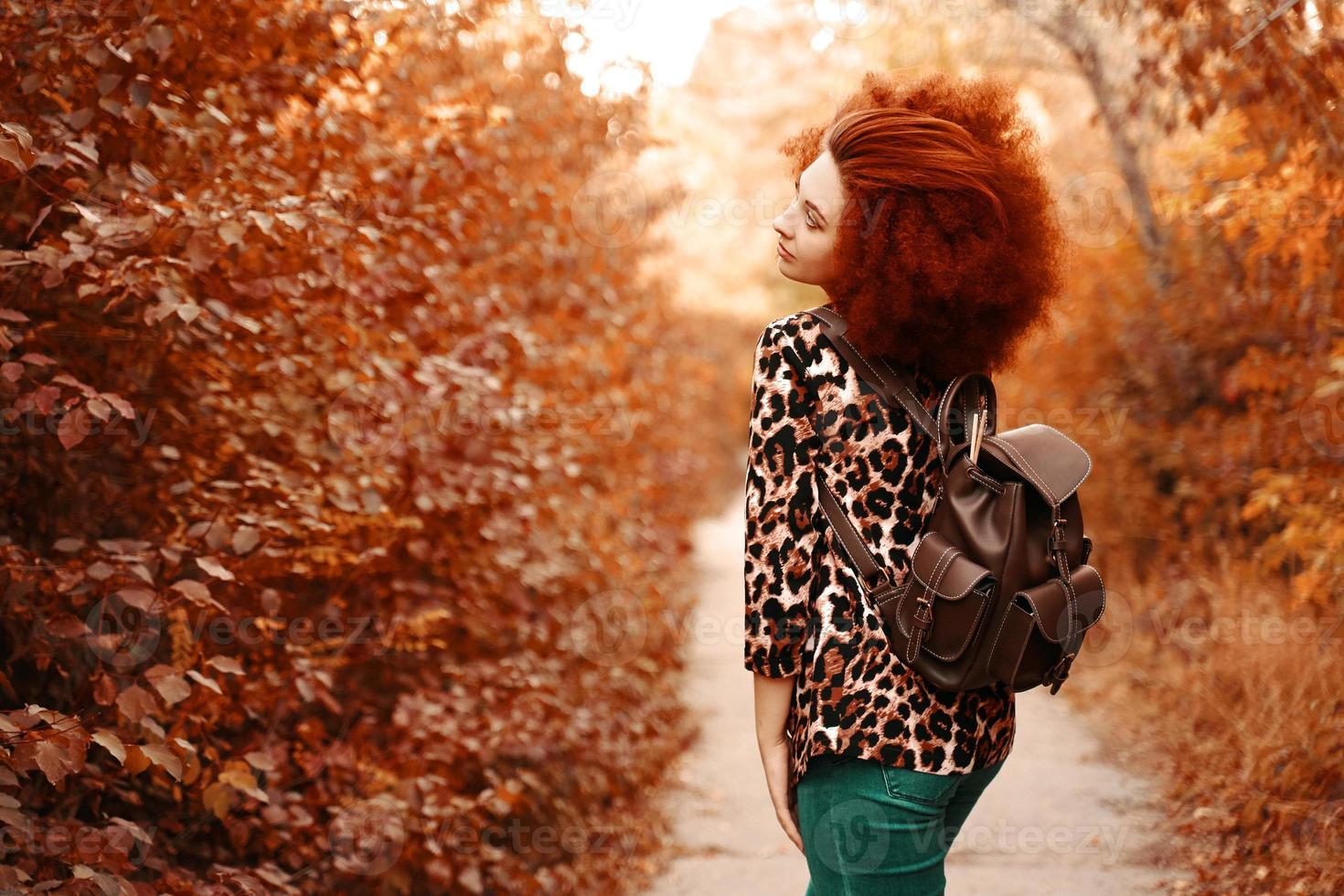 vrouw met afro loopt in het park in de herfst foto