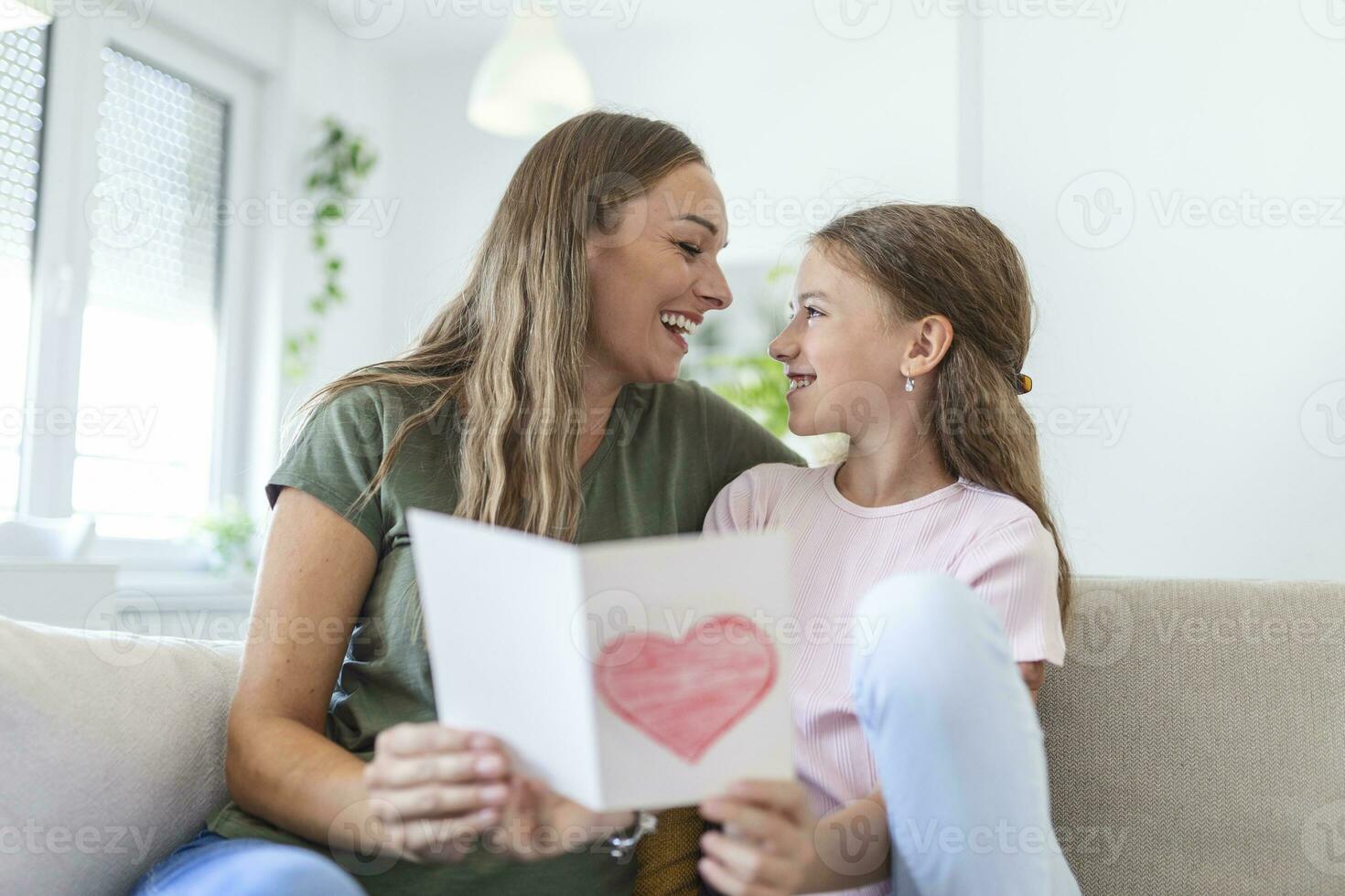 gelukkig moeder dag. kind dochter feliciteert mam en geeft haar ansichtkaart. mamma en meisje glimlachen en knuffelen. familie vakantie en saamhorigheid. foto