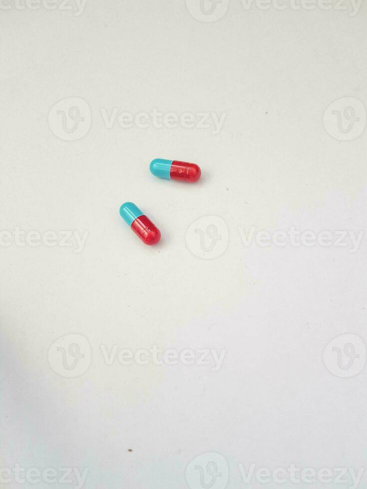 geïsoleerd wit foto van twee blauw en rood geneeskunde capsules.