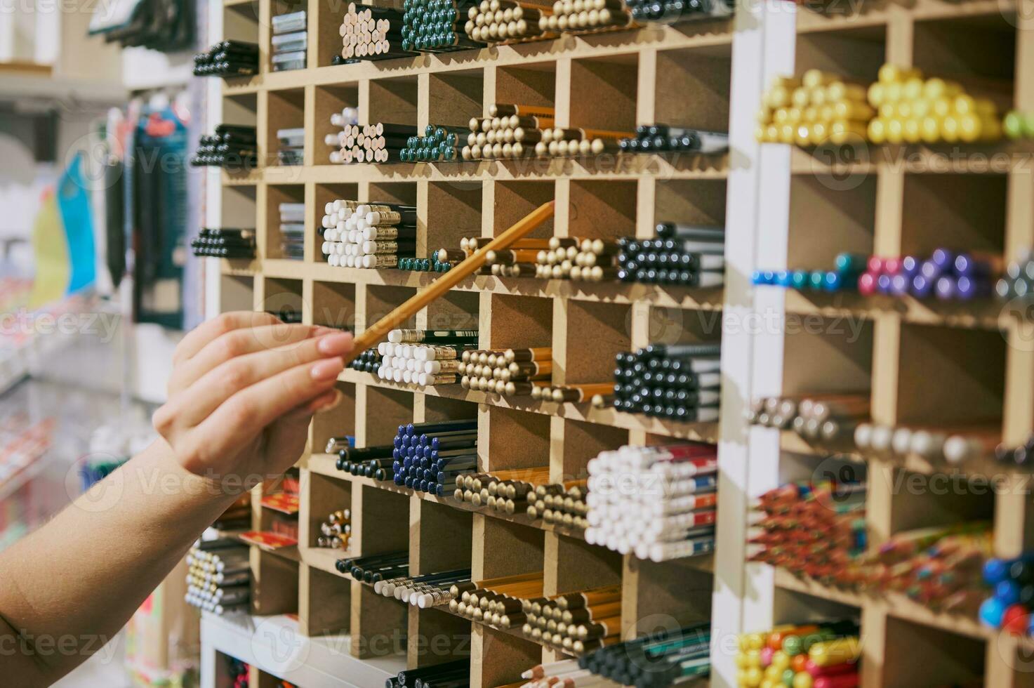 detailopname emale hand- duurt uit een grafiet potlood van een Scherm in school- schrijfbehoeften winkel. verkoper presteert merchandising foto