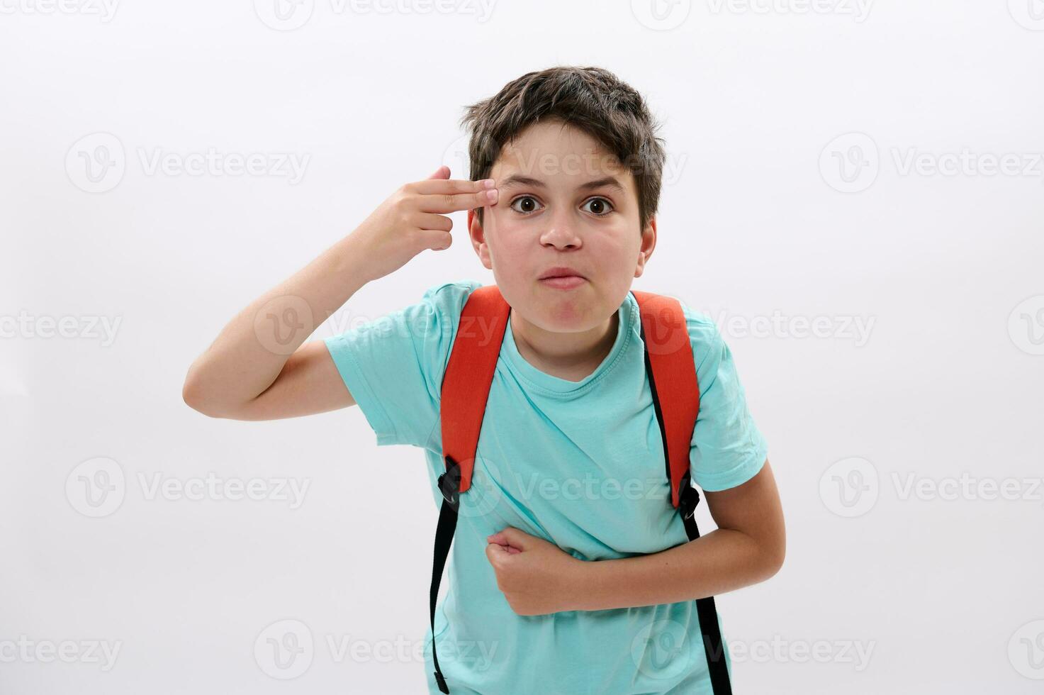 tiener schooljongen richten twee vingers Bij zijn tempel, tonen een het schieten geweer hand- gebaar, gevoel spanning, puberteit problemen foto