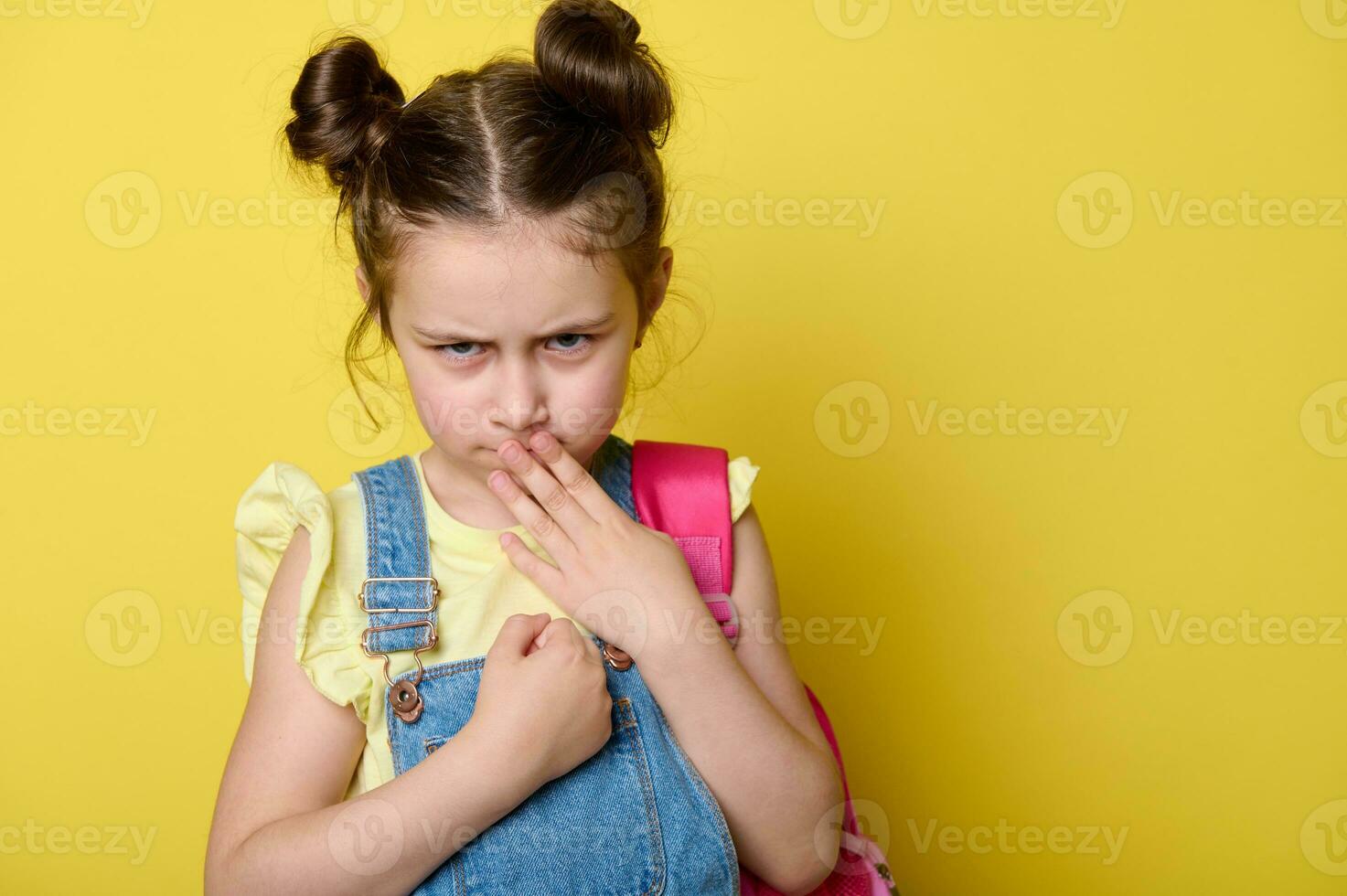 ontevreden school- meisje covers haar mond met haar hand, looks Bij de camera met een verdrietig gevoelig Look, geïsoleerd achtergrond foto