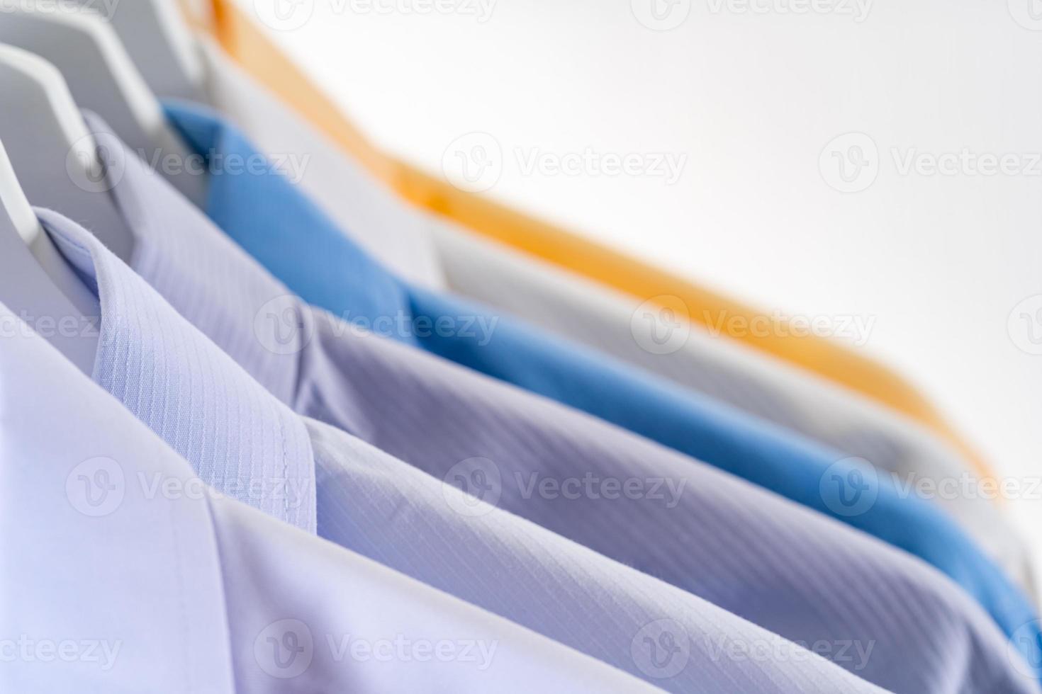 heren overhemden, kleding op hangers op witte achtergrond foto
