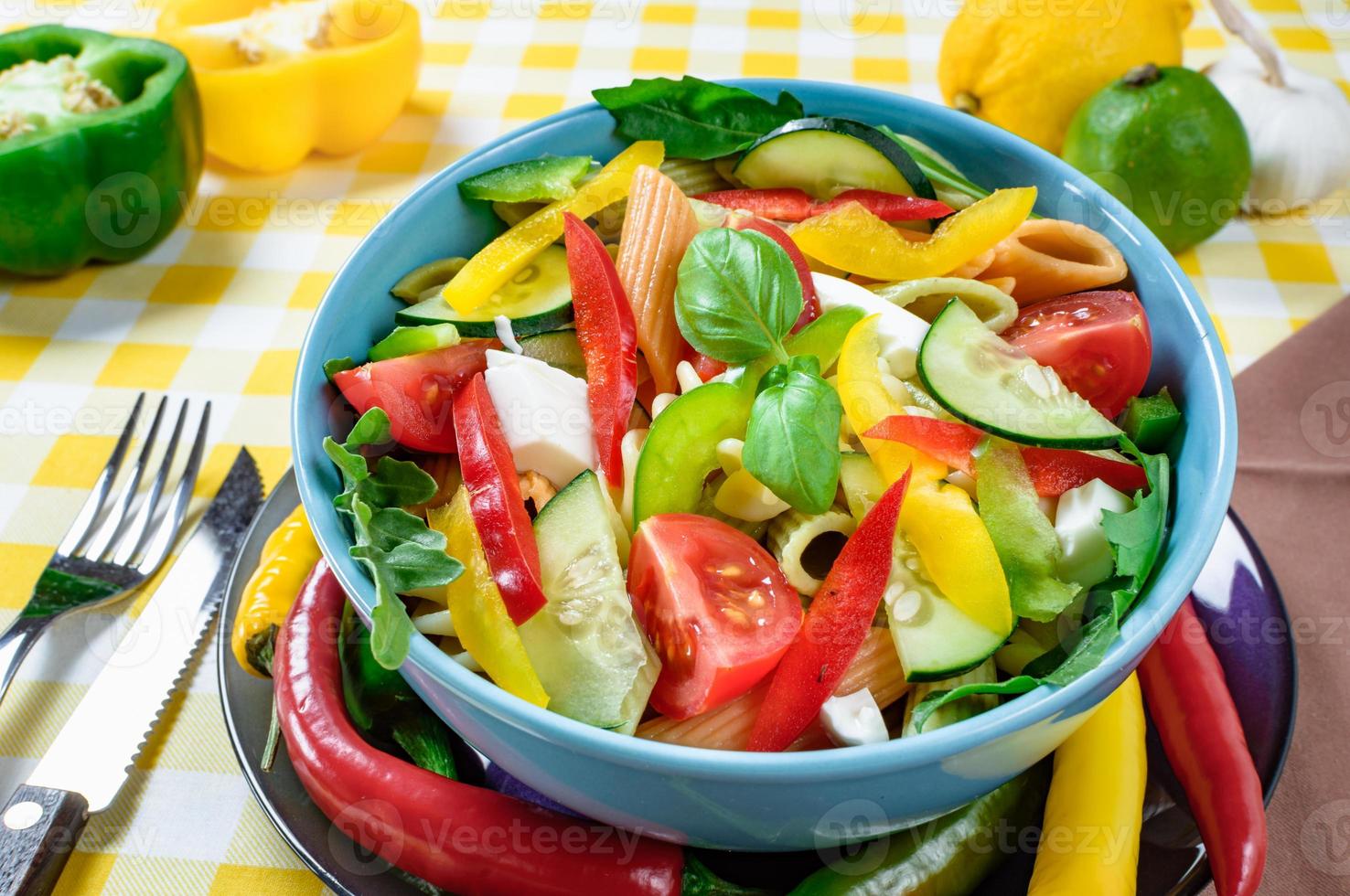 pastasalade met tomaat, rucola, komkommer, paprika, hete pepers, zwarte en groene olijven en kaas-feta. bovenaanzicht. foto