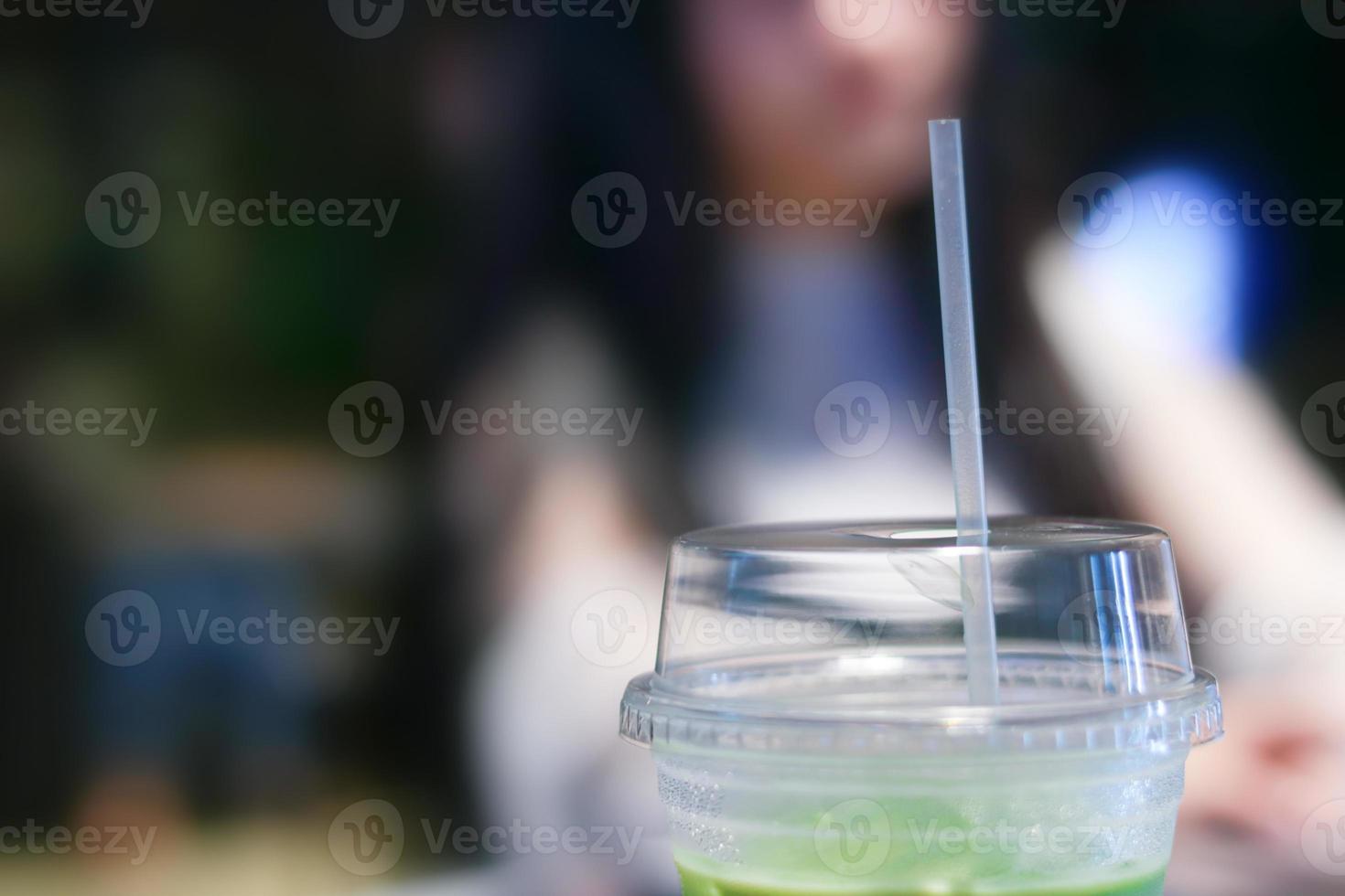 iced matcha groene thee latte op tafel met vrouwen die in de winkel werken foto