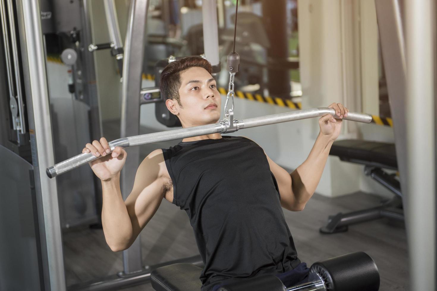 fit man trainen in de sportschool op een machine foto