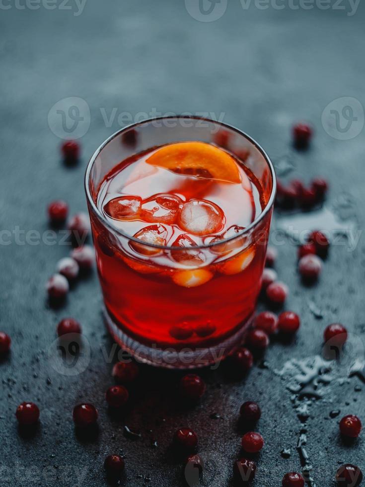 aperol spritz met ijs en veenbessen op een zwarte achtergrond. foto