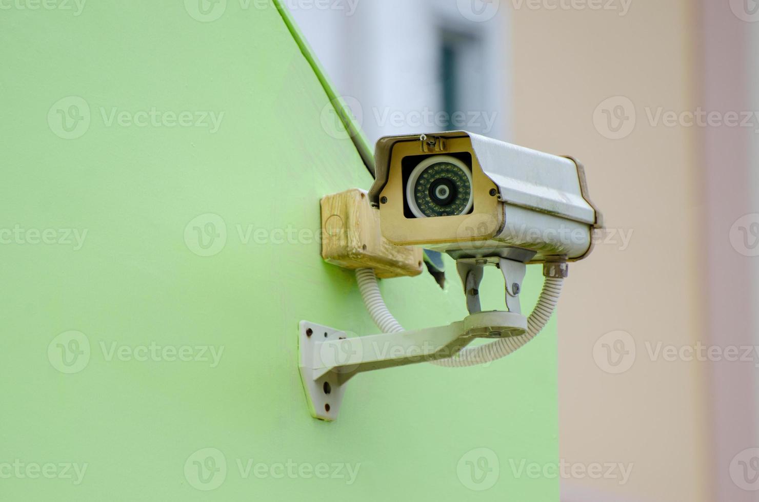 zilveren cctv-camera op de groene muur televisiecamera met gesloten circuit op groene achtergrond foto