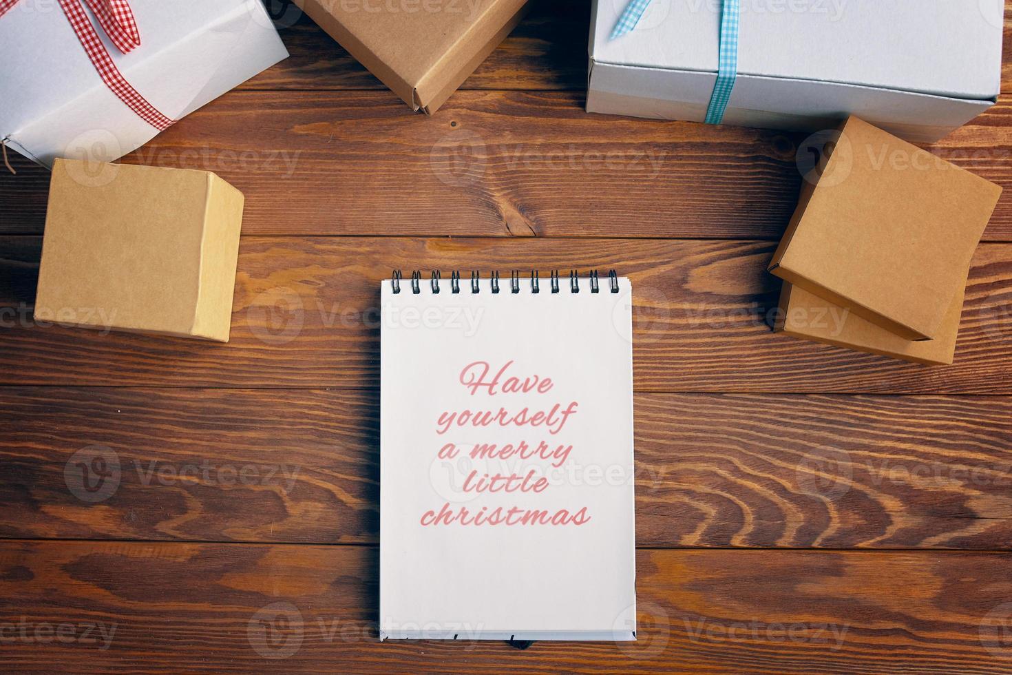 bovenaanzicht van spiraal notebook en geschenkdozen op houten tafel achtergrond. foto