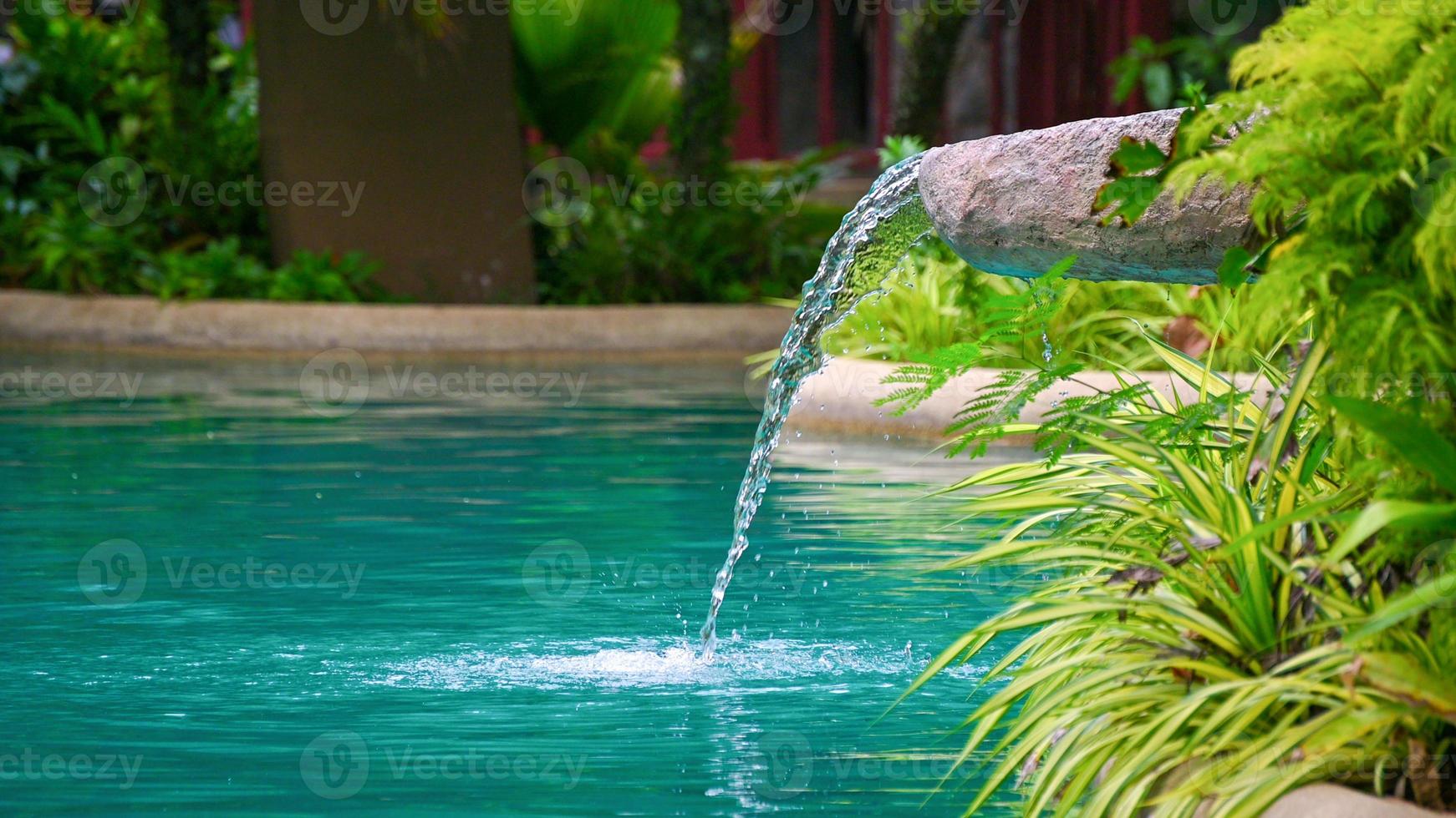water stromend water dat in de vijver valt, decoratie van de rand van de poep foto