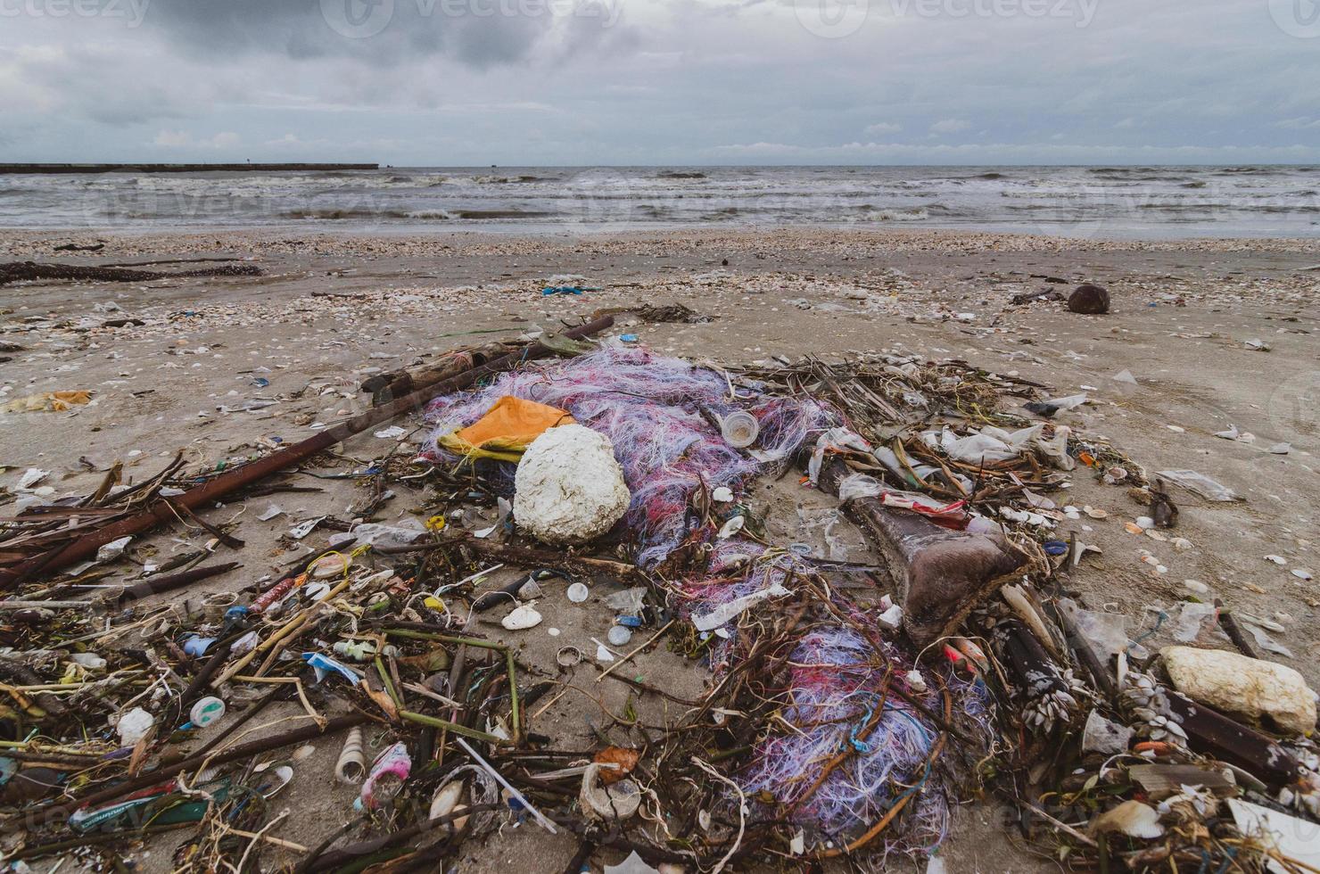 afval de strandzee plastic fles ligt op het strand en vervuilt de zee en het leven van het zeeleven gemorst afval op het strand van de grote stad. lege gebruikte vuile plastic flessen foto