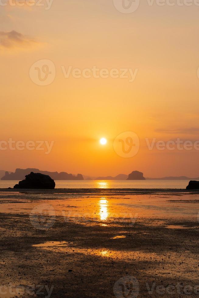 prachtige zonsondergang op het strand in de zomer met weerspiegeling van de zon in het water foto