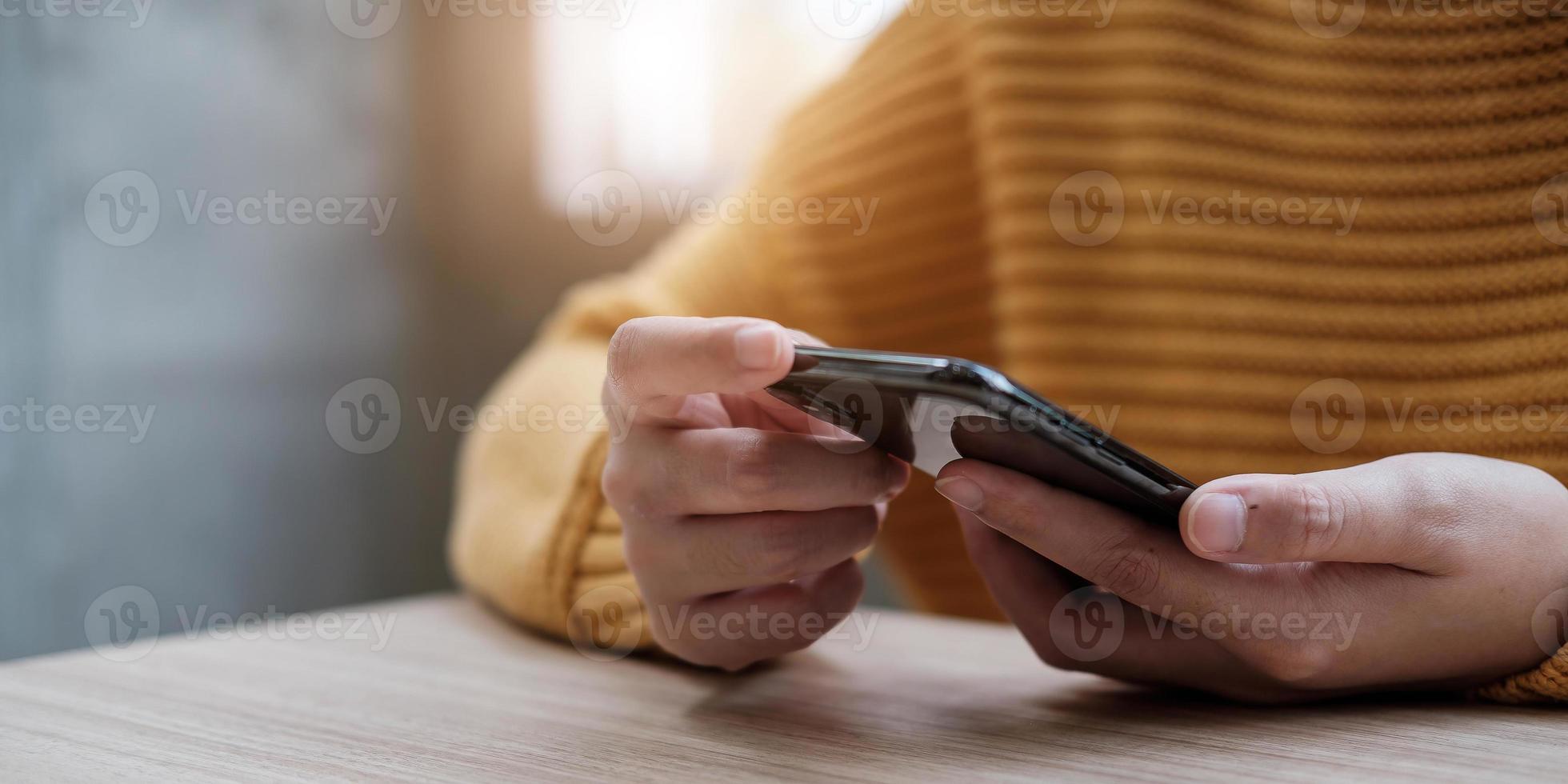 close-upbeeld van een vrouw die mobiele telefoon vasthoudt en gebruikt foto