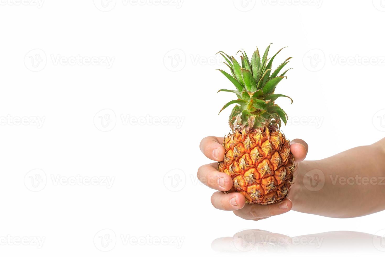 baby ananas in de menselijke mannelijke hand, geïsoleerd op een witte achtergrond. foto