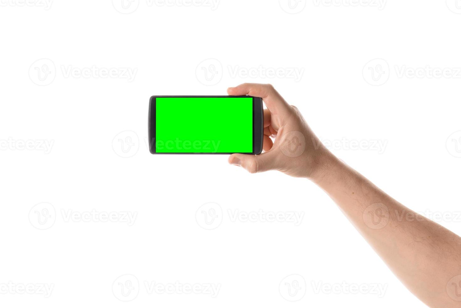 mannenhand houdt zwarte smartphone vast. geïsoleerd scherm met Chromakey en allemaal geïsoleerd op een witte achtergrond. foto