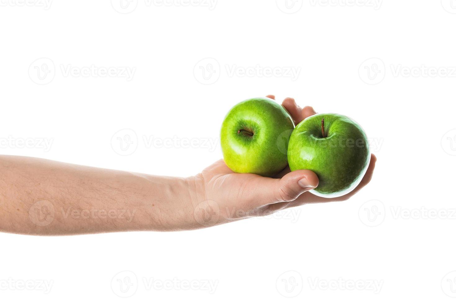 man met twee groene appels in zijn hand. geïsoleerd op een witte achtergrond. foto