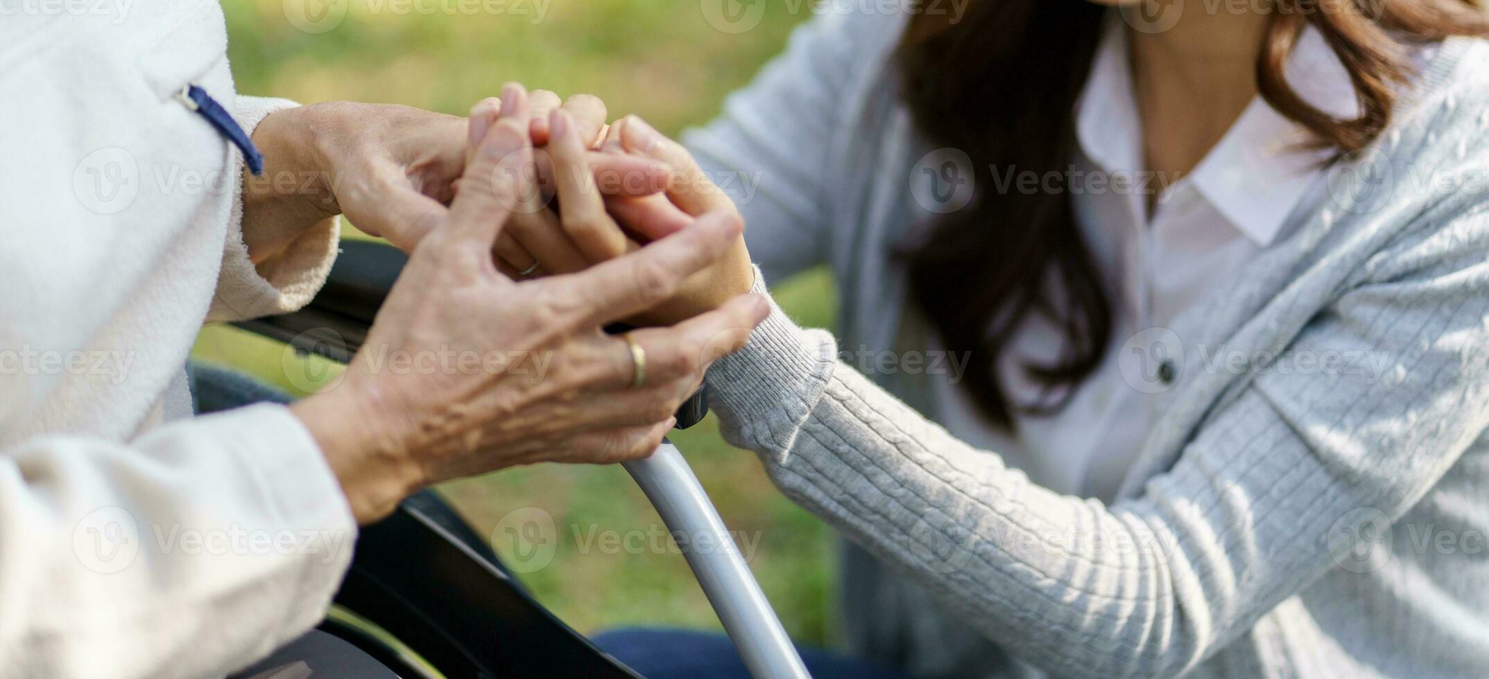 Aziatisch senior vrouw in rolstoel met gelukkig dochter. familie verhouding gepensioneerd vrouw zittend Aan rolstoel in de park leeftijd zorg Bij pensioen huis. foto