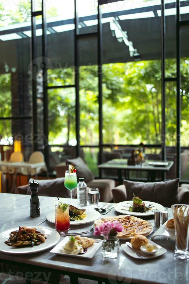 luxe tafel instellingen voor prima dining geserveerd en versierd tafel met voedsel voor gasten in de restaurant foto