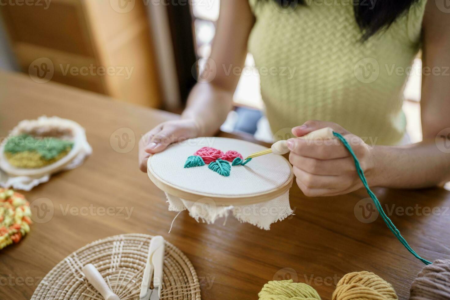 stempel naald. Aziatisch vrouw maken handgemaakt hobby breiwerk in studio werkplaats. ontwerper werkplaats handgemaakt ambacht project diy borduurwerk concept. foto