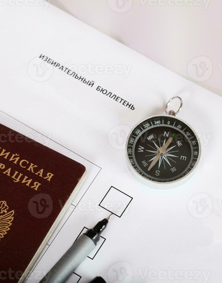 magnetisch kompas, Russisch voorbij gaan aan en zwart pen Aan stemming papier. foto