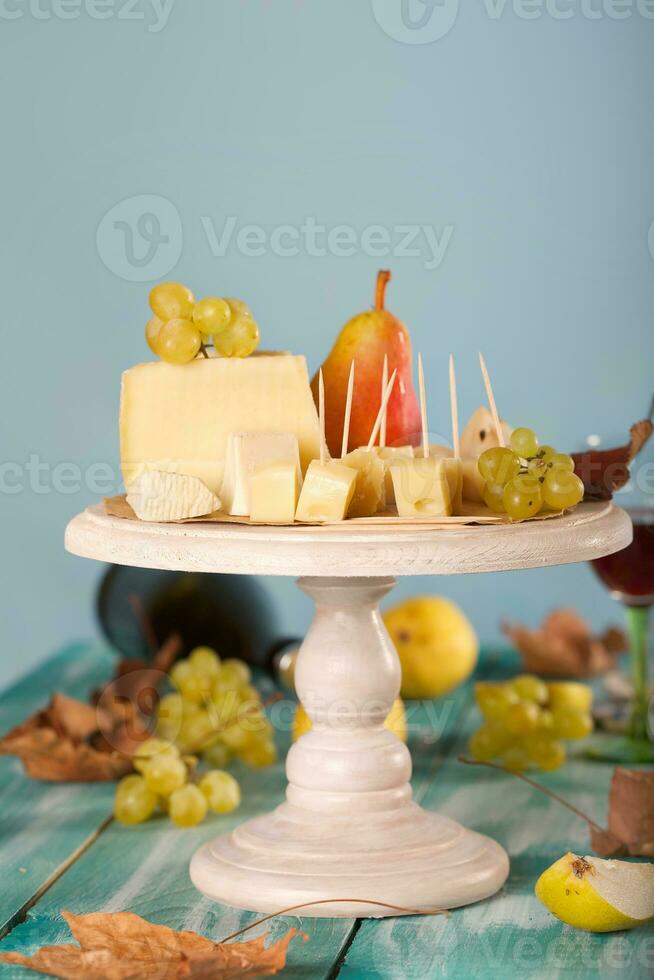 kaas plakjes, Peer, en druiven Aan een houten stellage. foto