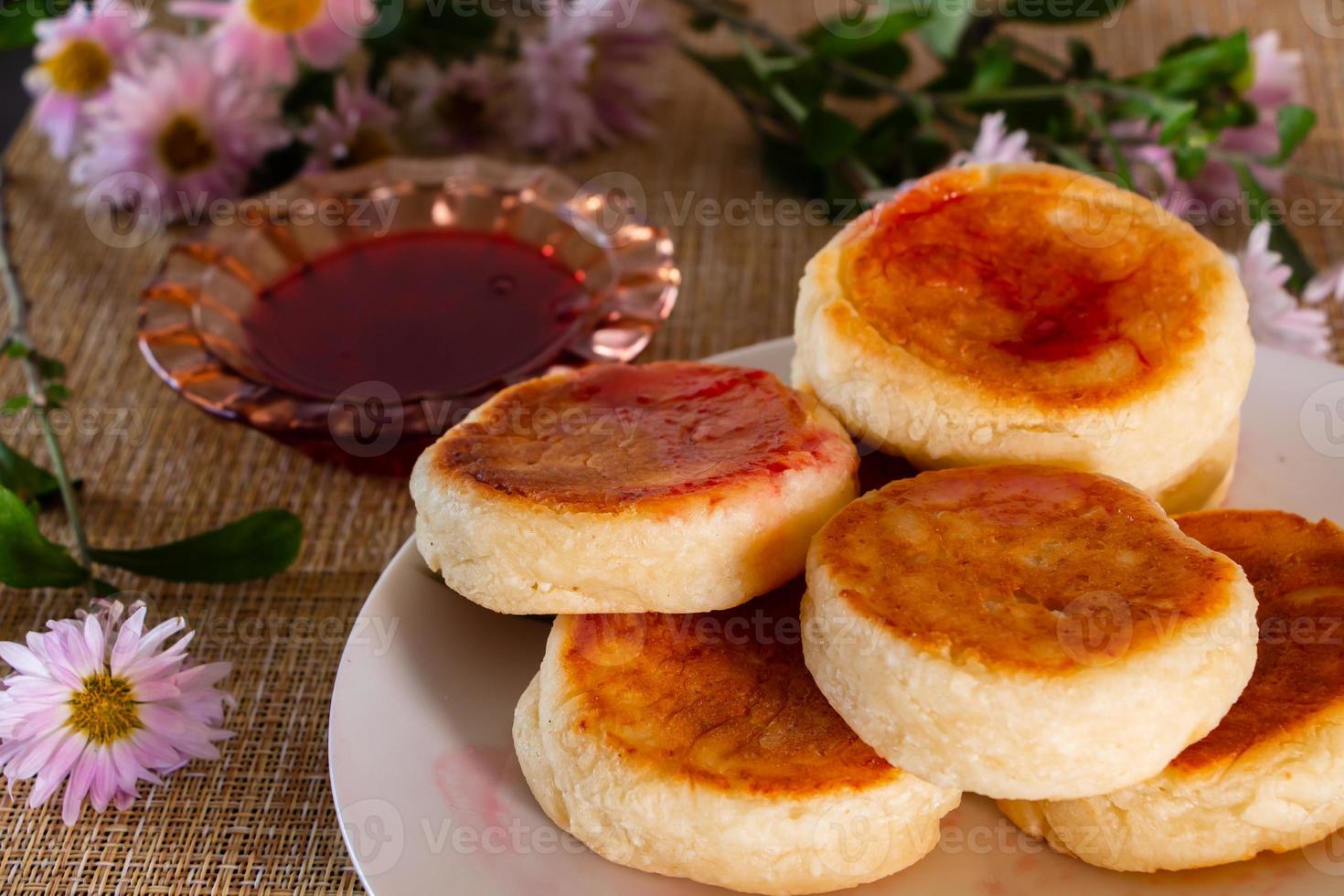 zelfgemaakt ontbijt - kwarkpannenkoekjes op een bord met jam en zure room. foto