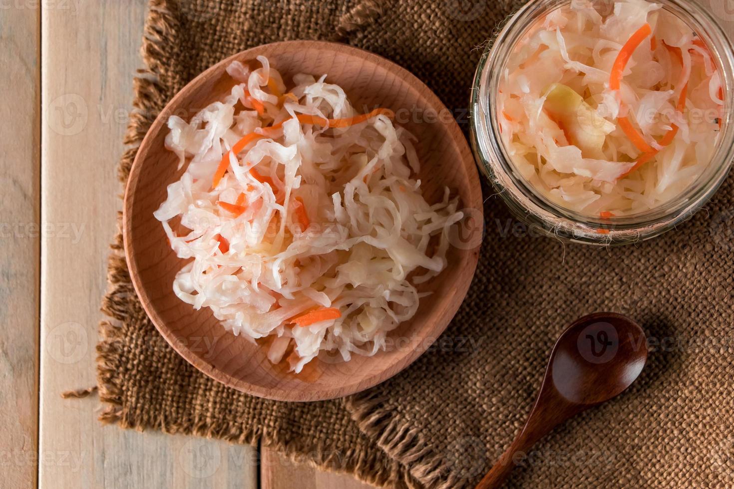 zelfgemaakte zuurkool op een linnen achtergrond. rustieke stijl, ingeblikte groenten op een lichte houten achtergrond. eco food, de trend van gezond eten. foto