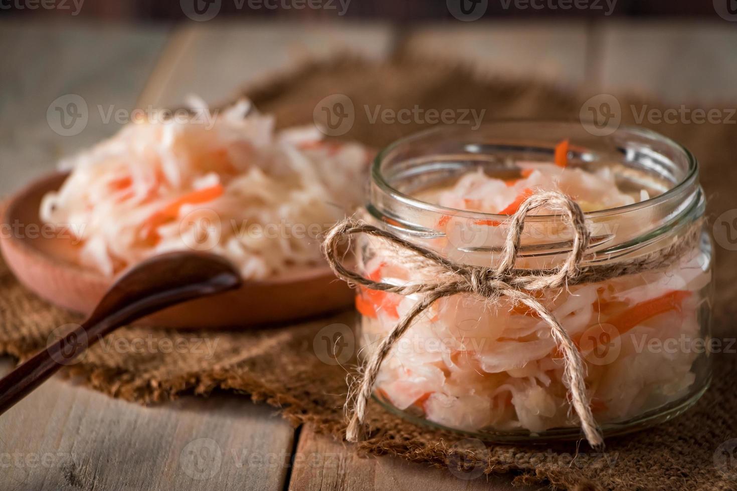 zelfgemaakte zuurkool op een linnen achtergrond. rustieke stijl, ingeblikte groenten op een lichte houten achtergrond. eco food, de trend van gezond eten. foto