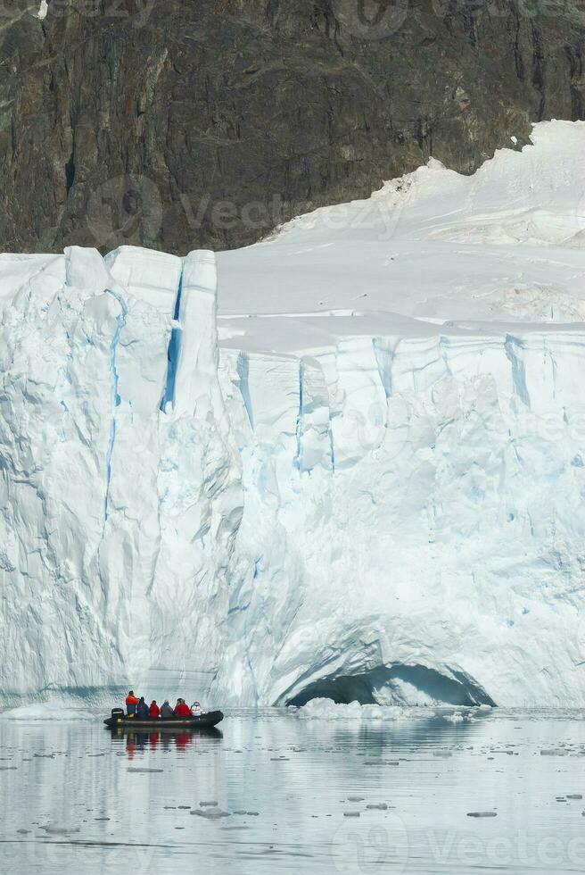 toeristen observeren een gletsjer Aan de antarctica, paradijs baai, antartiek schiereiland. foto