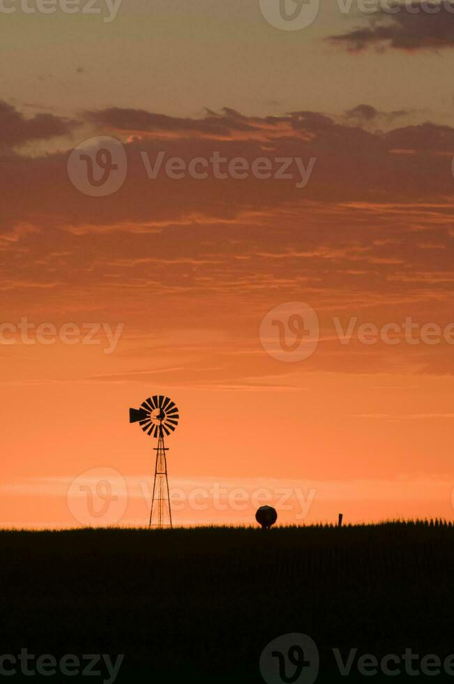 windmolen in platteland Bij zonsondergang, pampa, patagonië, argentinië. foto