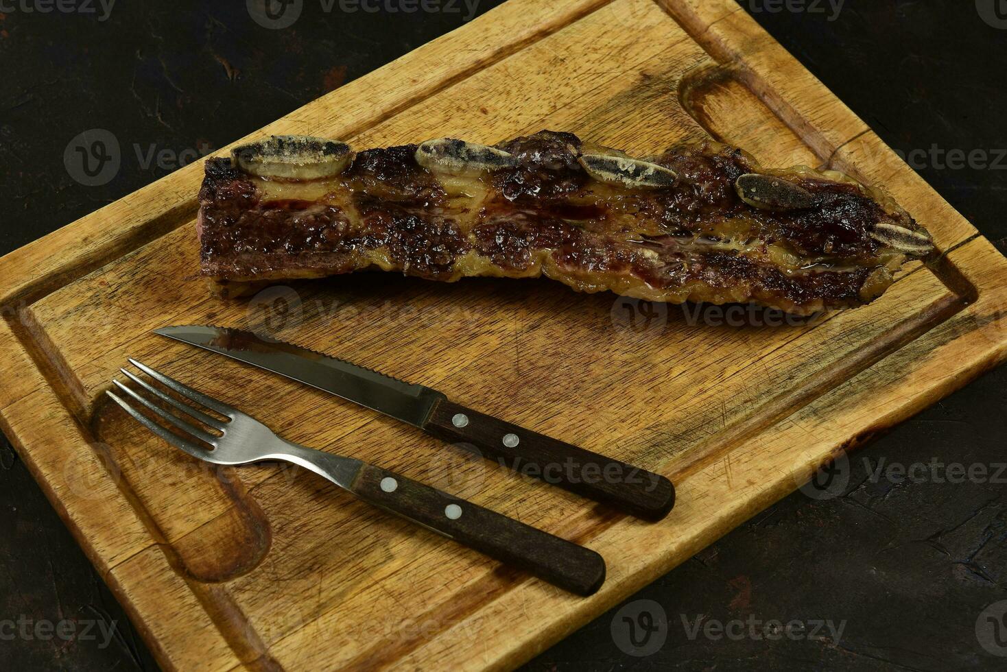 geroosterd rundvlees ribben gepresenteerd Aan de tafel, traditioneel Argentijns keuken, asado barbecue, Patagonië, Argentinië. foto