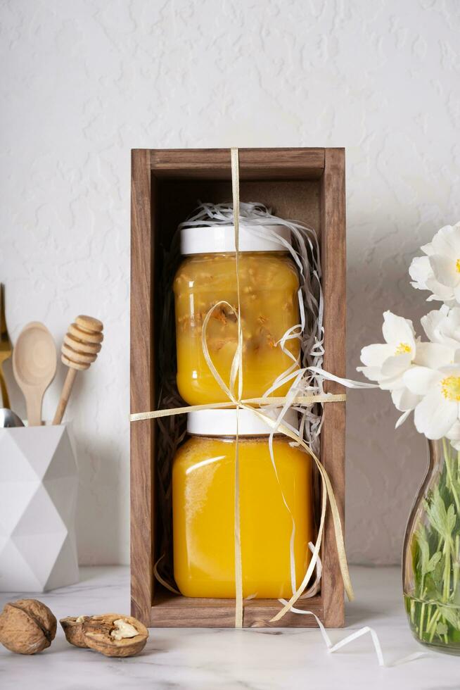 reeks van potten met honing en noten honing in houten doos Aan de keuken tafel foto
