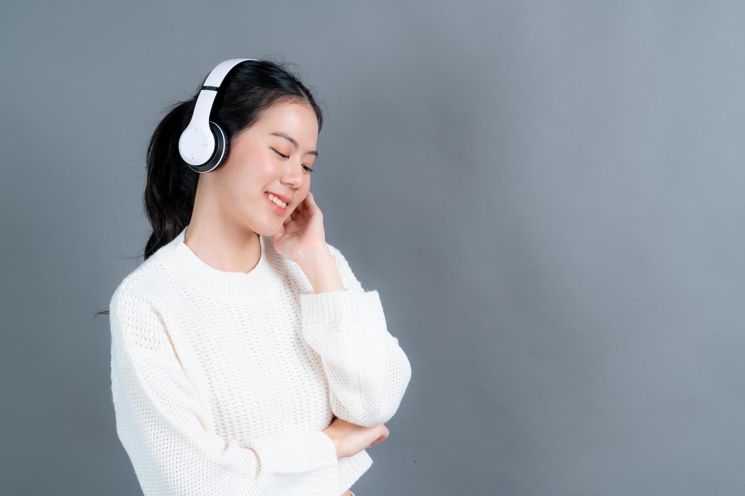 jonge aziatische vrouw die naar muziek luistert met een koptelefoon foto