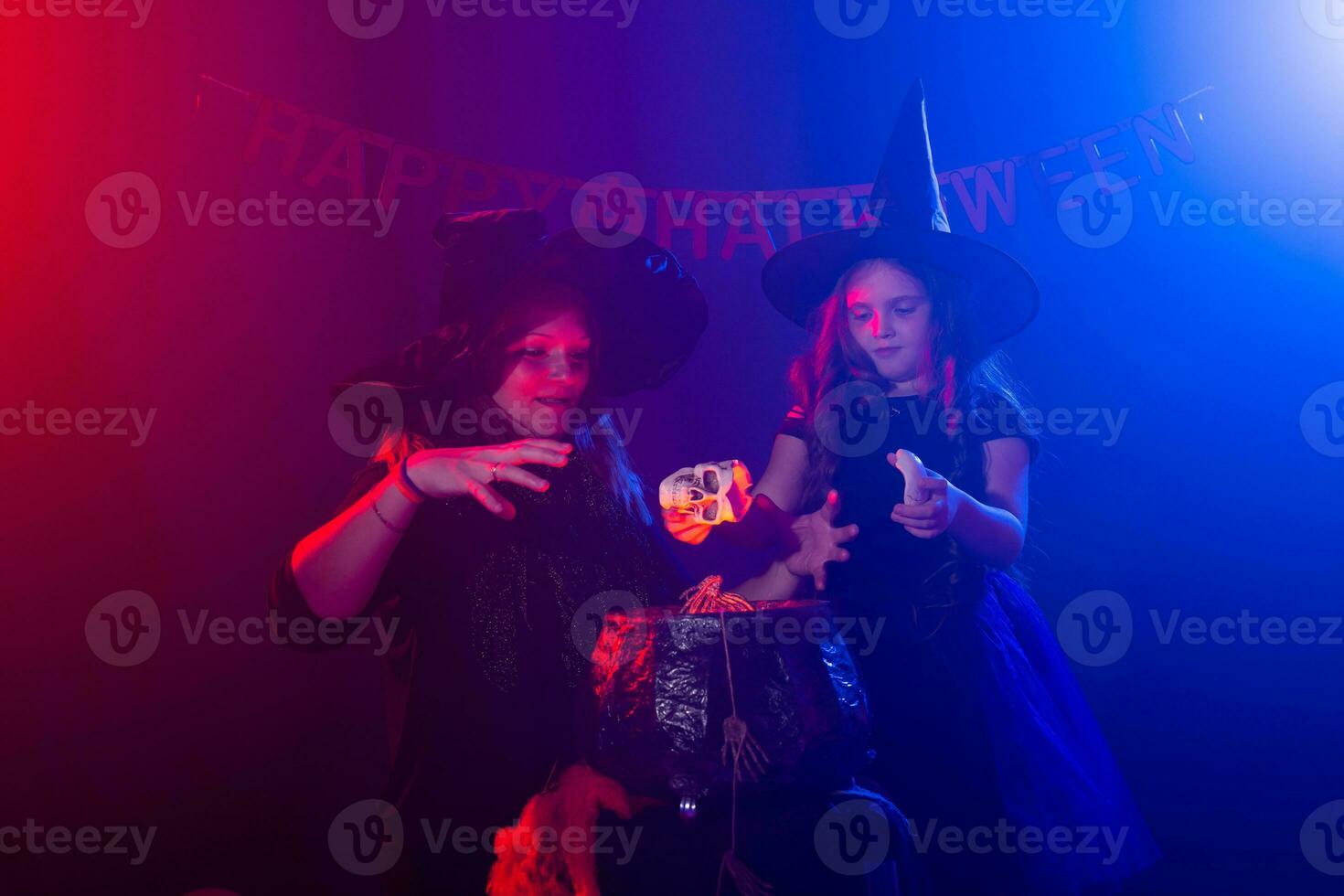 twee halloween heksen maken een toverdrank en toveren in halloween nacht. magie, vakantie en mysticus concept. foto