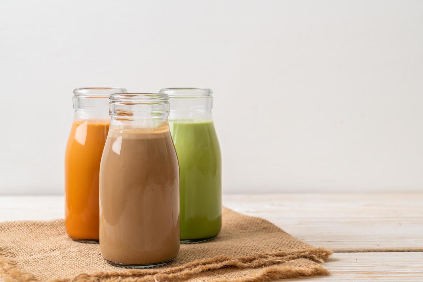 thaise melkthee, matcha groene thee latte en koffie in fles foto