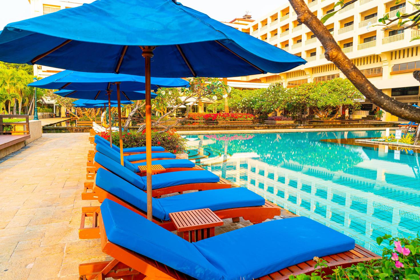 mooie parasol en stoel rond zwembad in hotel en resort foto