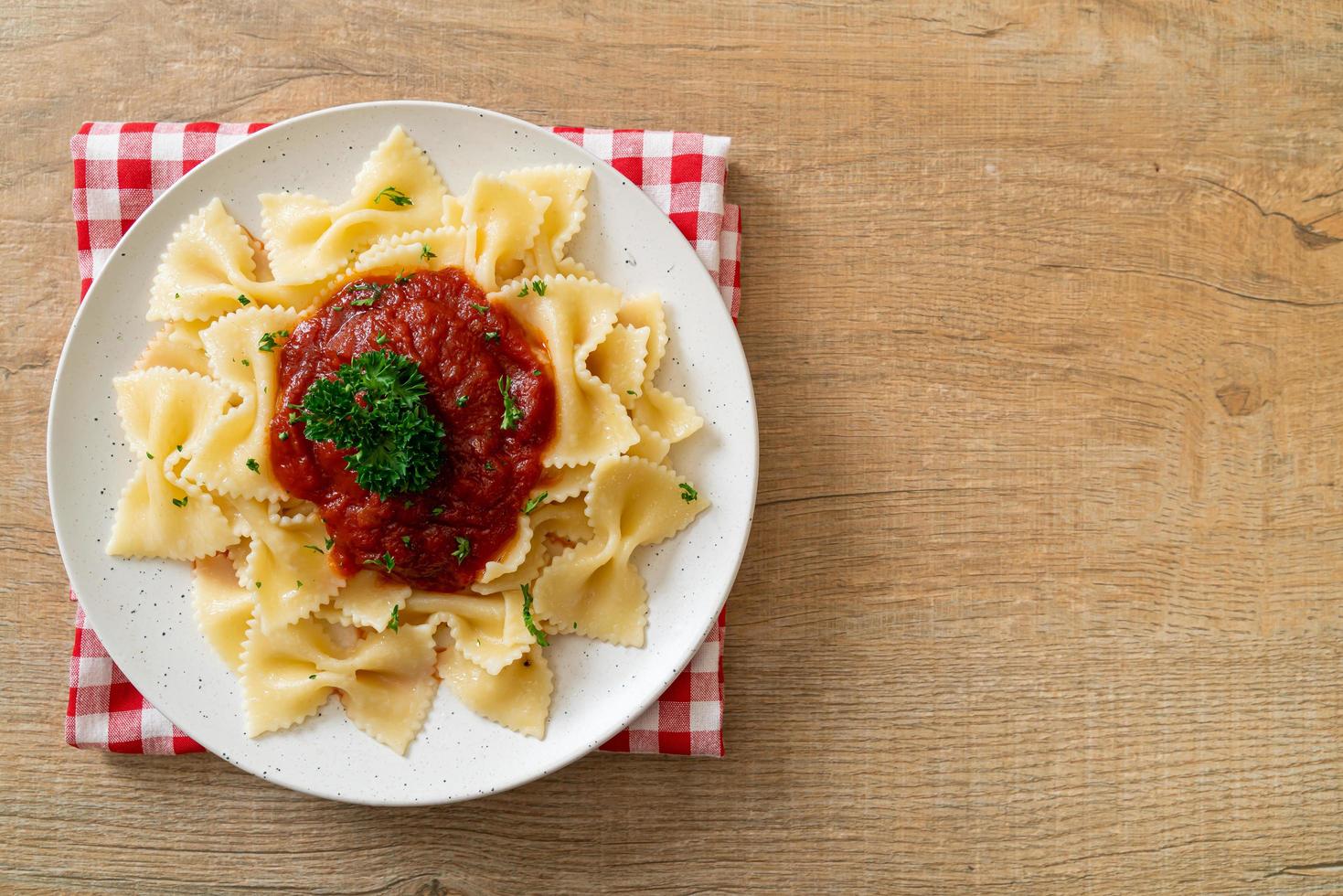 farfalle pasta in tomatensaus met peterselie - italiaans eten foto